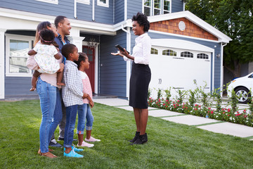 Real estate agent showing a family a house