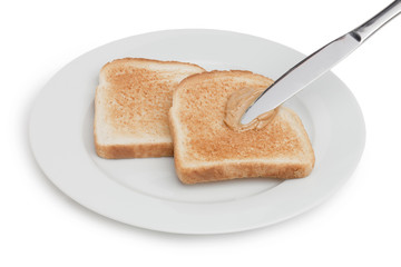 spreading peanut butter on toasted bread