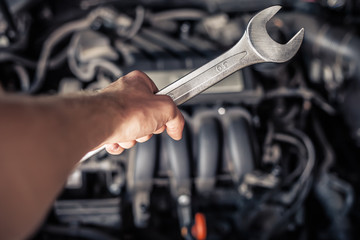 Hand of car mechanic with wrench. - obrazy, fototapety, plakaty