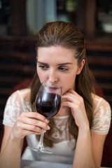 High angle view of happy woman drinking wine glass