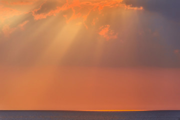 Fototapeta premium Rays of evening sun over sea