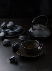 Obraz na płótnie Canvas Teapot with tea cup and black makarons