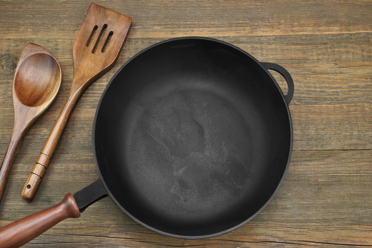 New Clean Empty Cast Iron Frying Pan On Wooden Background