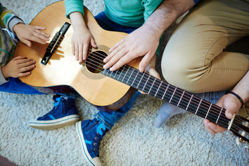 Touching strings of guitar