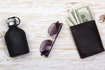 gentlemanly set:  sunglasses, perfume, wallet with money on wooden background