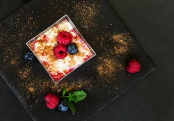Fototapeten glass dessert with yogurt cream and red fruits over slate © TTLmedia