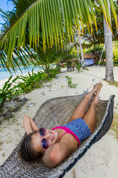 Girl in hummock on tropical beach