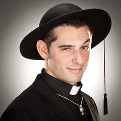 handsome attractive priest portrait on a grey background