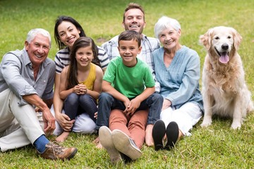 Fototapeta premium Portrait of cheerful extended family sitting in the park