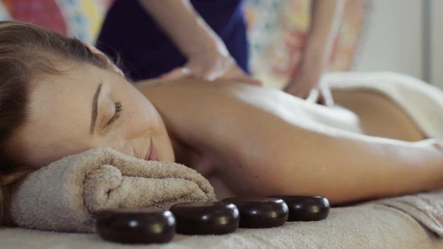 Relaxed woman getting massage at exotic spa