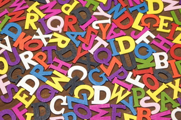 Random English Wooden Multicolored Letters On The Brown Wood Bac