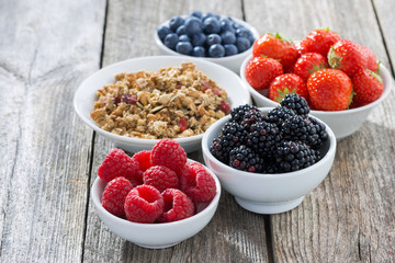 garden berries and muesli on wooden background