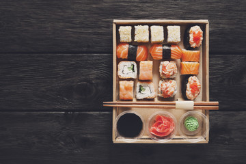 Set of sushi maki and rolls at black rustic wood.