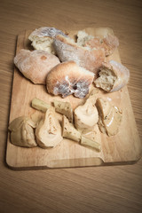 Fresh home bread and marinated artichokes on the light wooden cu