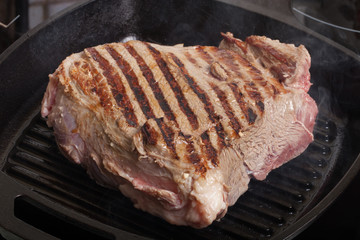 Large piece of fresh beef meat prepared on a grill pan