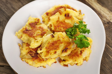 Frisch ausgebratene Rösti auf einem weißen Beilagenteller serviert