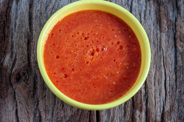 Homemade tomato sauce in yellow bowl on wooden table