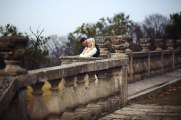 blonde bride and brunette groom walking near  old castle