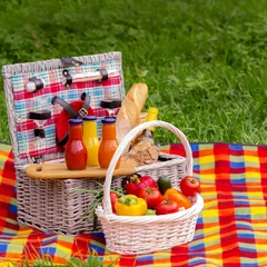 Foto auf Leinwand Picnic on the grass. Picnic basket with vegetables and bread. A © Julia29photo