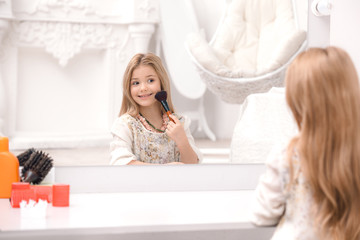 Cute little girl applying makeup