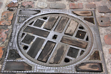 plaque d'égout fonte et bois