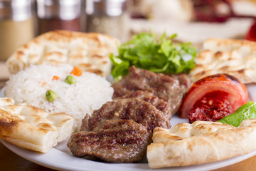 Delicious Turkish Traditional Kebab Kofte with pilaf on white plate (meatballs)
