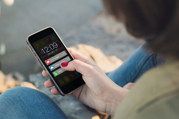 Woman touch the screen of her smartphone with notifications