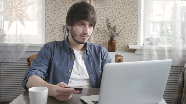 Happy Young Man Freelancer with Modern Laptop Buying by  Credit Card. Online Shopping