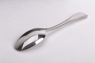 Stainless steel kitchen dessert spoon isolated over the white ba