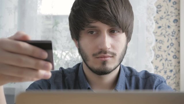 Happy Young Man Freelancer with Modern Laptop Buying by  Credit Card. Online Shopping