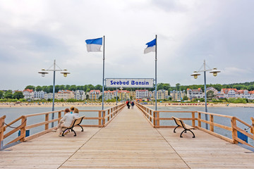 Bansin, Usedom, Germany - June 27, 2012: Pier of the baltic sea spa town Bansin - a famous tourist hotspot. Pier sign labeled with sea spa town Bansin (Seebad Bansin). - obrazy, fototapety, plakaty