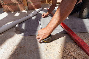 Worker prepare to cut the vapor barrier (water resistant / vapor permeable / roof foil)