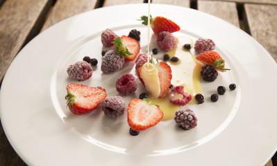 Delectable frozen summer berries with warm white chocolate sauce 
