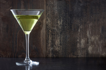 Green apple cocktail on black stone background
