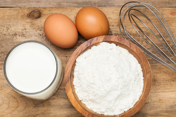 Eggs,flour, milk on a wooden worktop
