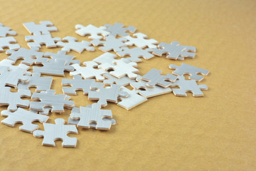 Close up silver puzzle on brown backgrpound