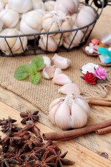 Raw garlic has health benefits on wood background.