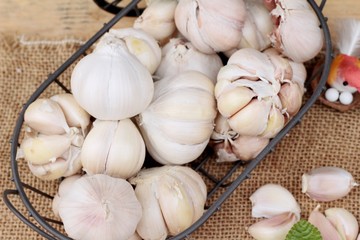 Raw garlic has health benefits on wood background.
