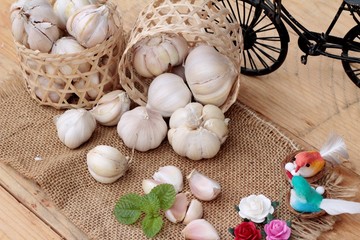Raw garlic has health benefits on wood background.