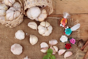 Raw garlic has health benefits on wood background.