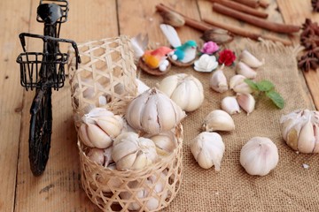 Raw garlic has health benefits on wood background.