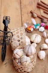 Raw garlic has health benefits on wood background.