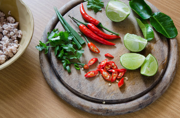 Ingredient of Thai cooking have Chili,coriander,lemon and bergamot leaves on wood block whit pork