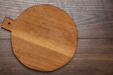 Empty round cutting board on a wooden table.Top view