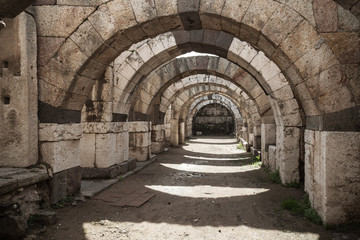 Fototapeta na wymiar Empty stone corridor with arcs and columns