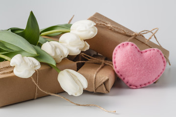 Fresh tulips and gift box over white background