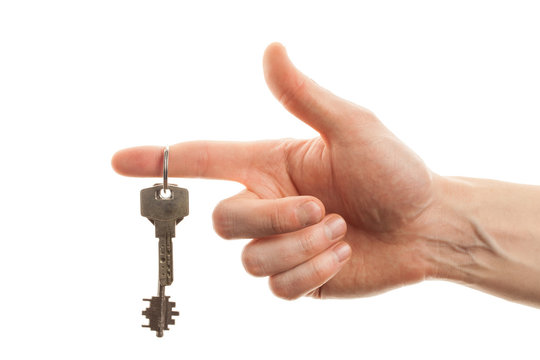 Hand holding the key of a new home isolated on white background