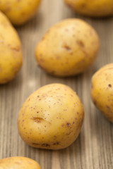 Fresh potato on wooden table, selective focus.Close-up studio ph