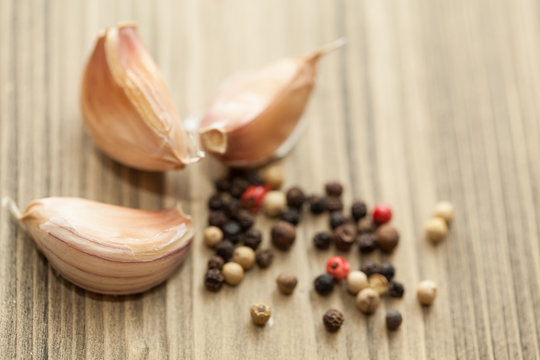 Fresh garlic and pepper on wooden table, selective focus. Close-