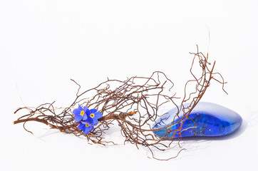 Lapislazuli mit blauer Blüte und feinem Zweig auf hellem Hintergrund Balance Meditation Heilung 